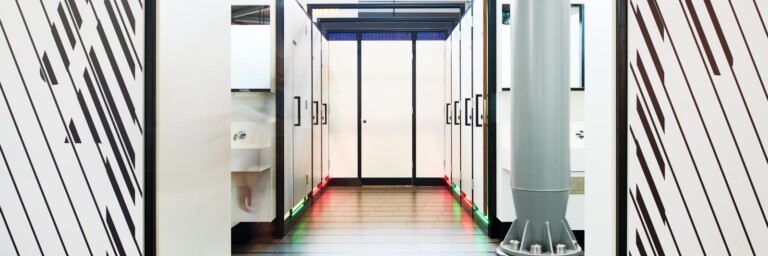 Eine moderne WC-Anlage mit roten und grünen Leuchten, die anzeigen, welche Toiletten schon besetzt oder noch frei sind.