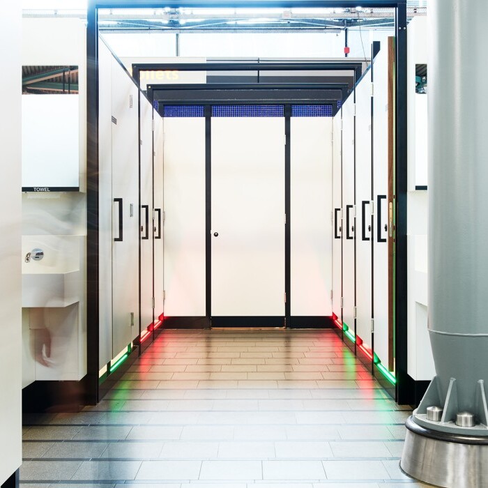 Eine moderne WC-Anlage mit roten und grünen Leuchten, die anzeigen, welche Toiletten schon besetzt oder noch frei sind.