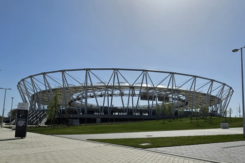 Ein modernes Stadion mit einem runden, offenen Dach.
