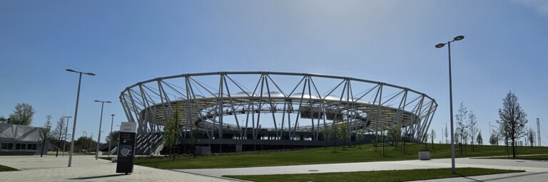 Ein modernes Stadion mit einem runden, offenen Dach.