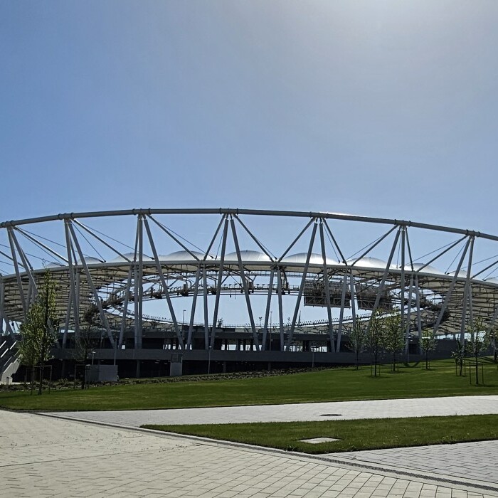 Ein modernes Stadion mit einem runden, offenen Dach.