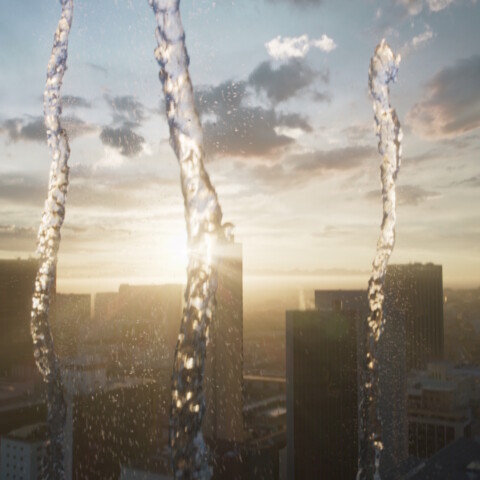 Wasserstrahlen im Vordergrund, vor einer Stadtsilhouette bei Sonnenuntergang.
