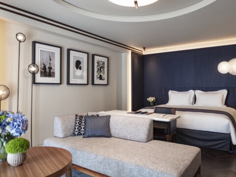 Moderne Hotelzimmer mit einem Doppelbett, einer Sitzecke und dekorativen Wandbildern.