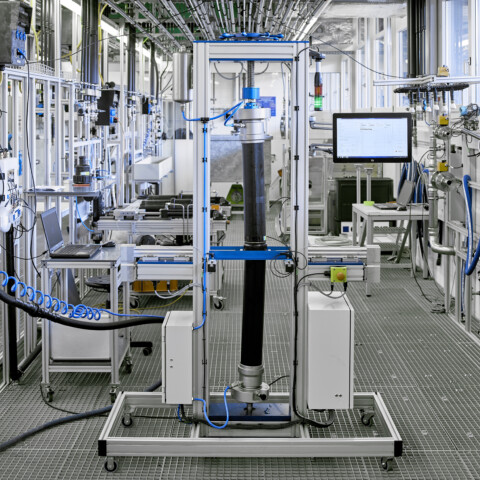 Ein detaillierter Blick in ein Prüflabor für Rohrleitungs- und Sanitärsysteme mit Leitungen, Ventilen und Messgeräten in einer industriellen Umgebung.