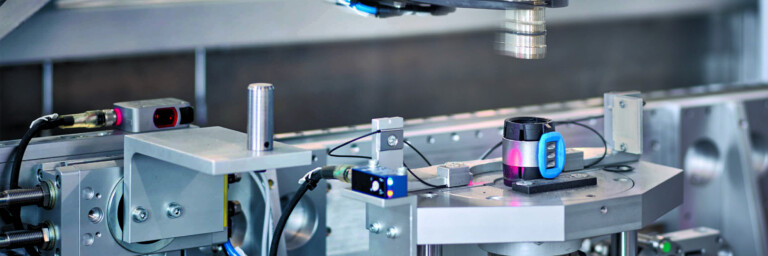 Mechanischer Arm mit Sensoren und Kabeln über einem Rohrleitungsfitting.