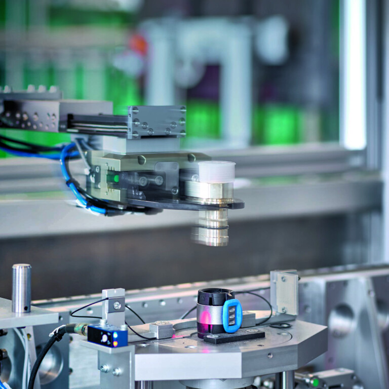 Mechanischer Arm mit Sensoren und Kabeln über einem Rohrleitungsfitting.