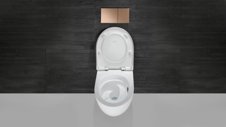 Acanto toilet with open lid and flush plate on a black wall.